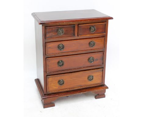 A reproduction small chest of two short and three long drawers raised on bracket feet, width 55cm.