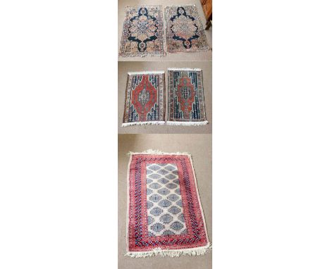 A near pair of Keshan rugs, 123 x 73cm, a further pair of Heriz examples and a Bokhara carpet on light brown ground within re