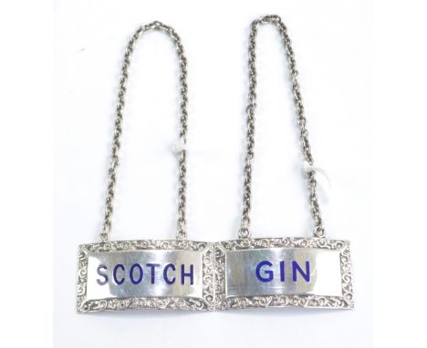 TURNER & SIMPSON LTD; a pair of Elizabeth II hallmarked silver rectangular enamel detailed decanter labels with cast foliate 