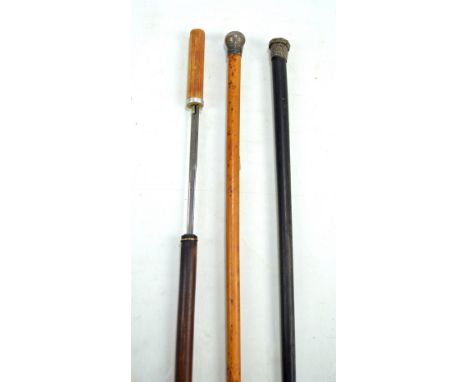 A sword stick with tapered blade stamped 'Toledo', blade length 69.5cm, a walking cane with hallmarked silver top and another