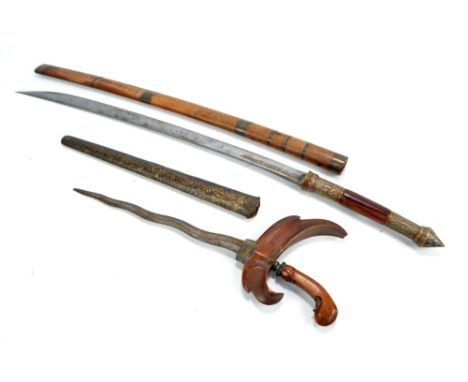 An Indonesian kris in scabbard and an Eastern curved sword in brass bound wooden scabbard (2).