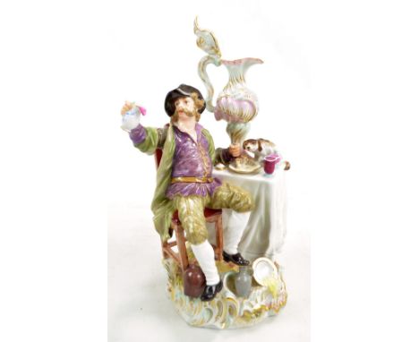 A Meissen porcelain figure of a seated man drinking wine at a table with a large ewer, marked to base, no.1447, height 22cm (