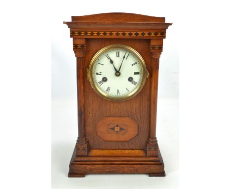 An oak cased eight day mantel clock, the dial set with Roman numerals, height 37cm.