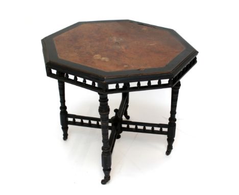 A late Victorian Aesthetic Movement amboyna veneered and ebonised octagonal centre table with pierced gallery frieze, four ri