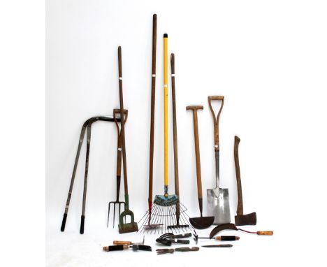 A group of various gardening hand tools to include hoe, fork, axe etc.