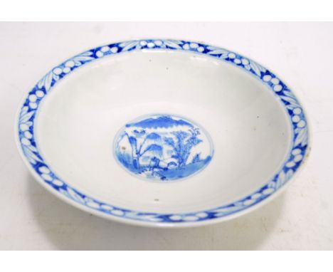 A Chinese porcelain circular bowl on cylindrical foot painted in underglaze blue with roundel depicting mountainous and figur