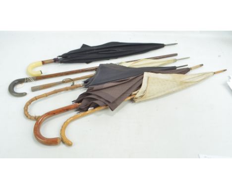 Five umbrellas and parasols and a horn handled walking stick with hallmarked silver collar, length 91cm (6).