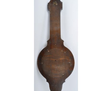 An early 20th century circa. 1920's oak banjo barometer having silvered face with carved Jacobean Revival manner motifs to to