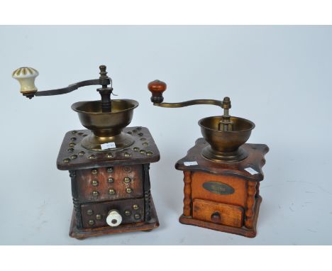 A pair of 20th century wooden coffee grinders. One having metal studded detailing with ceramic knob handle and the other havi