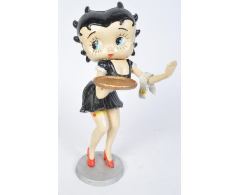 A retro vintage 20th Century cast iron figure of Betty Boop. In waitress attire with black hair, holding a serving tray and l