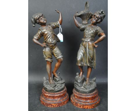 A pair of vintage 20th century spelter statues after the French artist H. Tremo of young boy and girl with flower basket. Bot