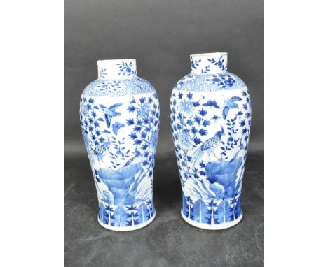 A pair of 19th century Chinese Oriental blue &amp; white ceramic Kang-xi vases having bulbous bodies with waisted stub necks.