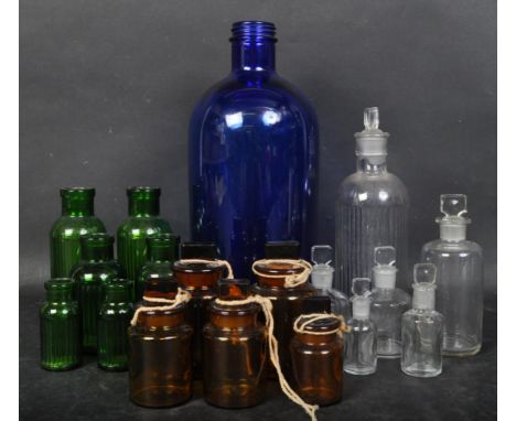 A collection of vintage 20th century clear, blue, green, &amp; amber Apothecary bottles of various sizes &amp; shapes. Some h