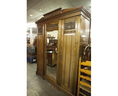 LARGE LATE VICTORIAN CARVED MAHOGANY WARDROBE OF ARCHITECTURAL STYLE WITH CENTRAL PEDIMENT TO THE CORNICE, ROCOCO CARVED DECO