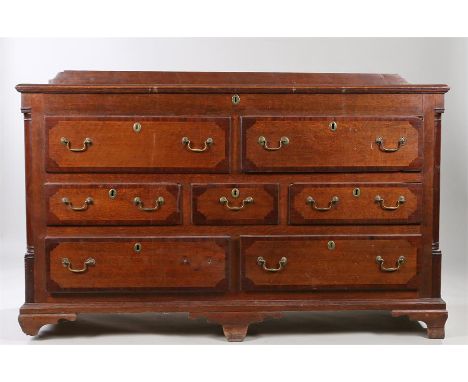 18th Century oak and mahogany banded side board, the rectangular top above seven drawers raised on ogee bracket feet, 158cm x