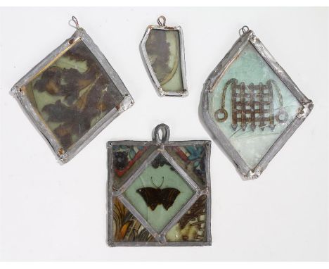Four painted / stained glass panels depicting a portcullis, butterfly and flowers, foliage and part portrait. various dates. 
