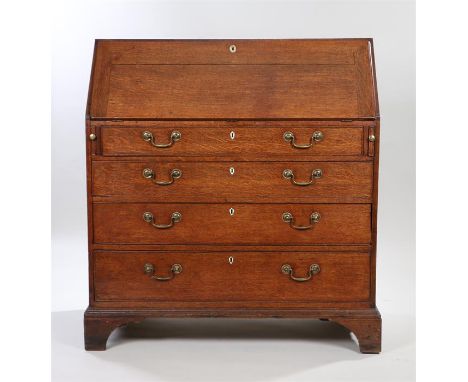 George III oak bureau, the rectangular top above a sloping fall enclosing small drawers and pigeon holes, four long graduated