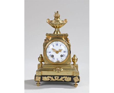 19th Century French gilt brass mantel clock, the flame urn finial top above a stepped case and stile feet, the white enamel d