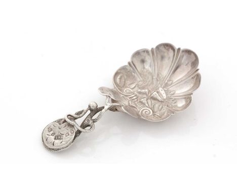 A Victorian silver caddy spoon, embossed in the bowl with a variety of seashells and fluting, the tendril stem with lily leav