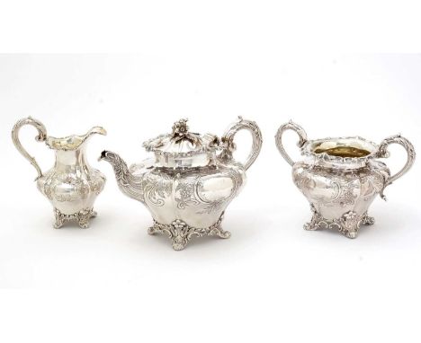 An early Victorian silver three-piece tea set, with shaped circular bodies, decorated with chased floral scrolls, floral scro