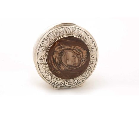 An early George III silver snuff box, circular with a chased floral scroll border, inset agate disc, gilt interior, unmarked,
