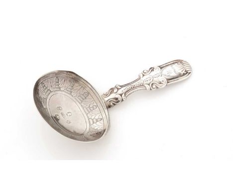 A George III silver engraved caddy spoon, with a decorative hollow handle, initialled "M" and a lip around the rear section o
