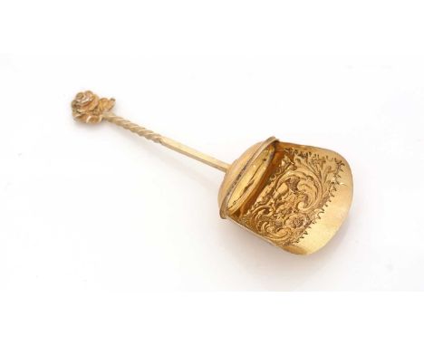 A late Victorian silver-gilt caddy spoon, in the form of a scoop with chased decoration, a part-twist stem and rose flower fi