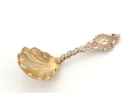 A Victorian silver Provincial caddy spoon, with shaped and fluted gilt bowl, decorated stem with a scrollwork terminal, crest