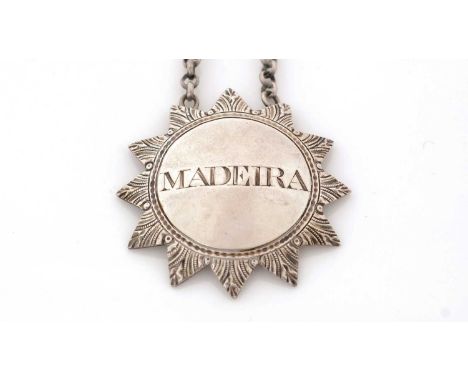 A George III silver wine label, in the form of a sunburst with chased detail around the border, incised "MADEIRA", by Susanna