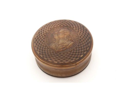 An early George III pressed horn and engine-turned snuff box, circular with a pull-off cover portraying King George III and h