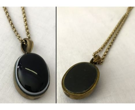 A vintage agate set mourning locket. Brass bale and surround black silk and glass to rear of locket front set with a large bl