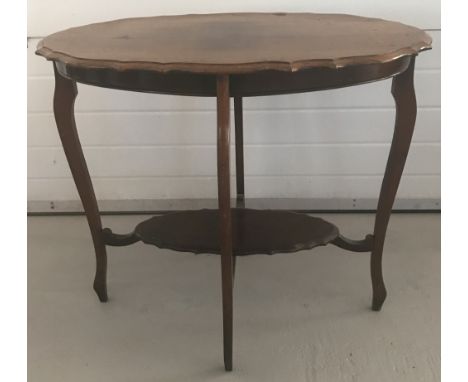 A vintage dark wood oval shaped occasional table with shaped detail to top and undershelf.  Approx. 73cm tall x 81cm wide.