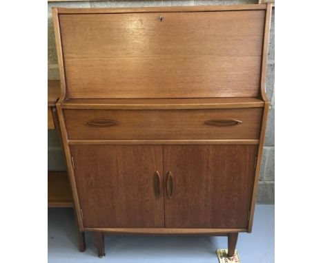 A vintage teak bureau with single drawer and double door cupboard. Interior stationary compartments to top and fixed shelf to