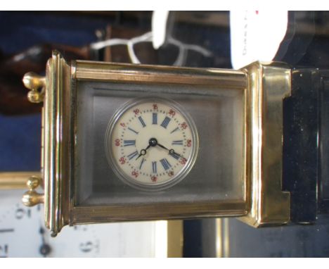 A MINIATURE BRASS CASED CARRIAGE CLOCK with inset porcelain panels, 6cm high 