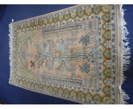 A PERSIAN "TREE OF LIFE" RUG with pale pink ground work with tree architectural columns and birds within a prayer niche, 125c