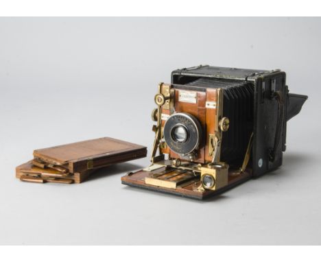 A Houghton Sanderson Hand and Stand Camera, quarter plate, mahogany and brass, black leather square tapered bellows, with gro