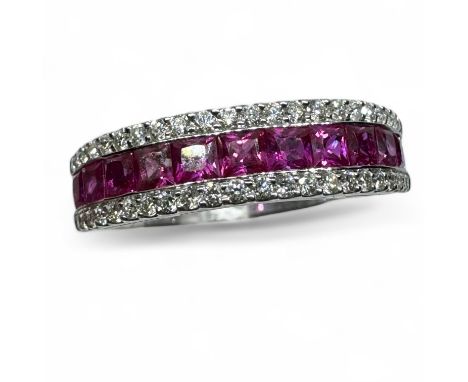 A ruby and diamond set dress ring, set with 11 channel set square cut rubies, flanked with two rows of claw set round brillia