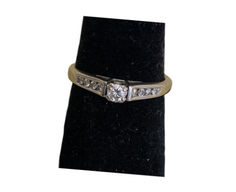 18ct white gold and diamond solitaire ring. Main stone diamond weight is approx 0.15ct. With four small channel set diamonds 