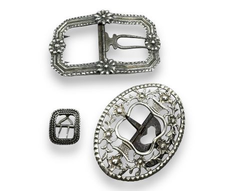  A group of antique silver and white metal buckles. Featuring a Georgian repousse octagonal buckle with four flowers; a small