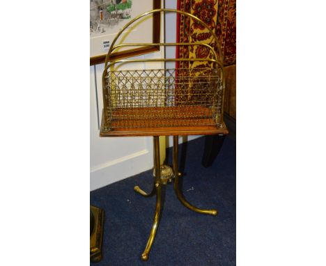 An Edwardian brass and mahogany swivel magazine rack, raised on ornate tripod supports, 74cm high