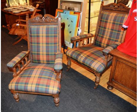 A pair of Edwardian oak his and hers open armchairs, each with floral swan neck top rail, over cushioned back and arms, on ba