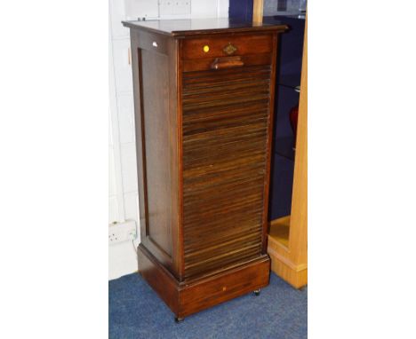 An oak tambour fronted music cabinet, label stamped 'The Ebus Cabinet', with roller shutter enclosing fitted drawers, 120cm h