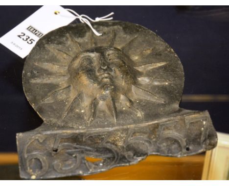 An antique lead fire insurance wall plaque, no.653557 (possible replica), with hammered sun dial motif, 16.5cm diameter