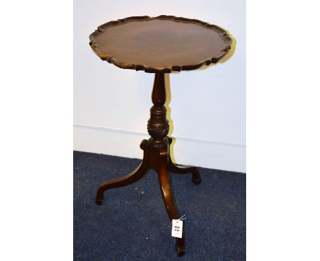 A 19th century mahogany pie crust table, the scalloped circular top on tulip baluster turned column, with ebony strung down s