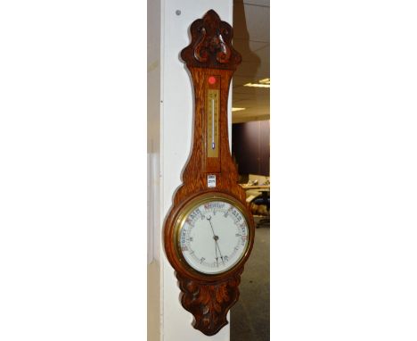 A carved oak banjo barometer, with thermometer dial above white enamel dial, stamped patent, 90cm high