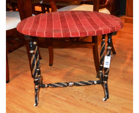A Victorian ebonised and gilt side table, the oval top on fluted spiral turned legs, downswept feet and ceramic castors, unit