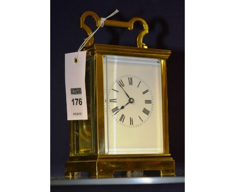 A brass carriage clock, with white enamel dial and carry handles, 19cm high