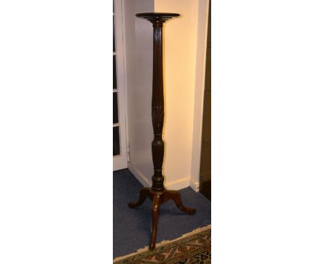 A mahogany torchere, raised on reeded turned column and tripod base, 152cm high