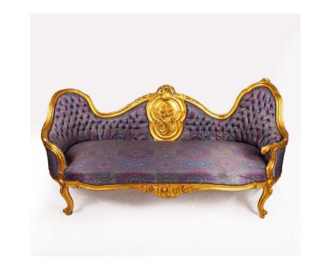 A beautiful French style sofa with lavender and magenta patterned cushion and sofa back. Accented with wooden carved gilded f