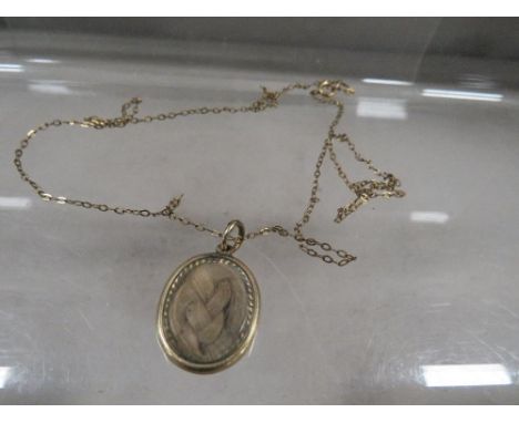 A 19th century pendant with woven hair and enamel detail 